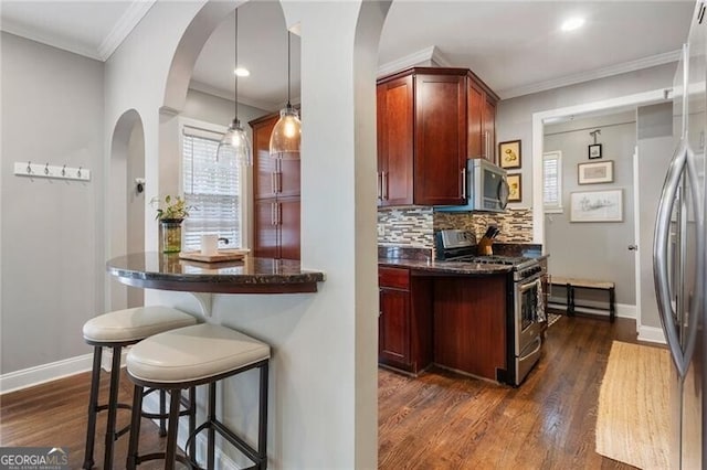 kitchen featuring stainless steel appliances, ornamental molding, backsplash, hanging light fixtures, and dark hardwood / wood-style floors