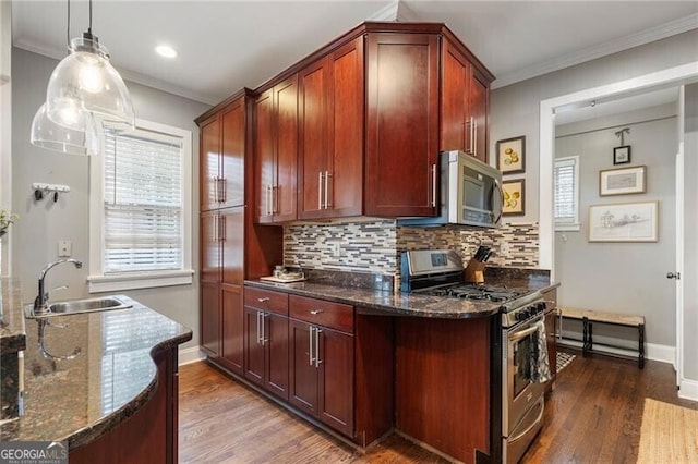 kitchen with sink, dark stone countertops, backsplash, hanging light fixtures, and appliances with stainless steel finishes