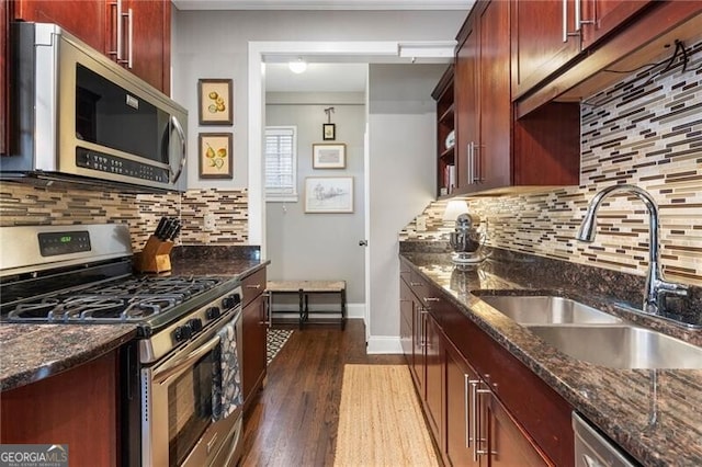 kitchen with sink, decorative backsplash, dark stone counters, and appliances with stainless steel finishes