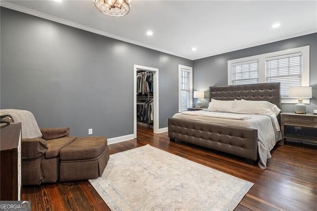 bedroom with ornamental molding, a walk in closet, and dark hardwood / wood-style floors