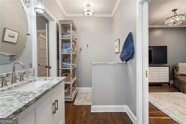 bathroom with hardwood / wood-style floors, crown molding, and vanity