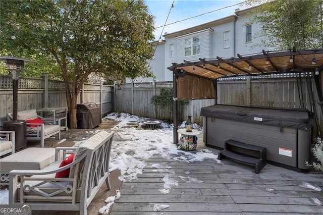 snow covered deck featuring a hot tub and area for grilling