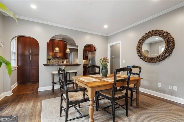 dining area with crown molding and dark hardwood / wood-style floors