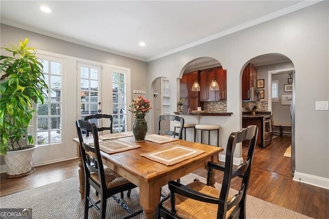 dining room featuring french doors, ornamental molding, a wealth of natural light, and dark hardwood / wood-style floors