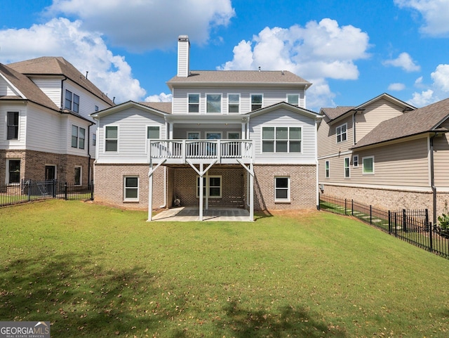 back of property with a lawn, a deck, and a patio area