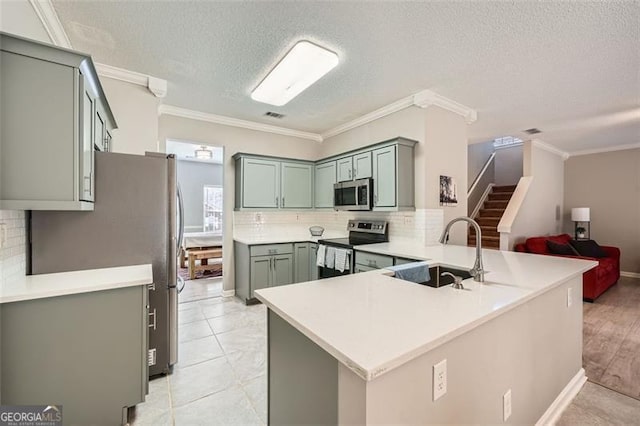 kitchen with kitchen peninsula, appliances with stainless steel finishes, backsplash, and sink