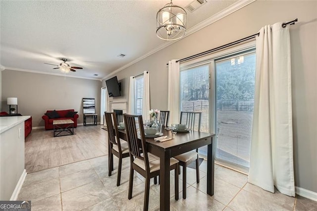 tiled dining space featuring ceiling fan with notable chandelier and ornamental molding