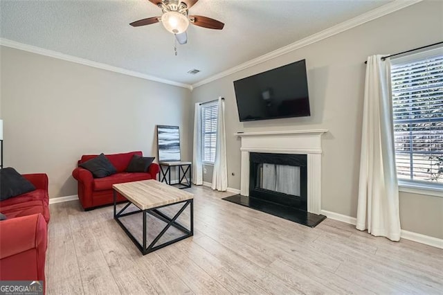 living room with a textured ceiling, hardwood / wood-style floors, ceiling fan, and crown molding