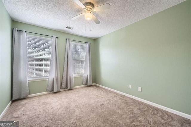 spare room with ceiling fan, carpet, and a textured ceiling