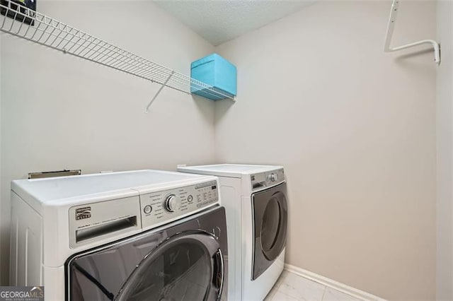 washroom with washing machine and dryer and light tile patterned floors