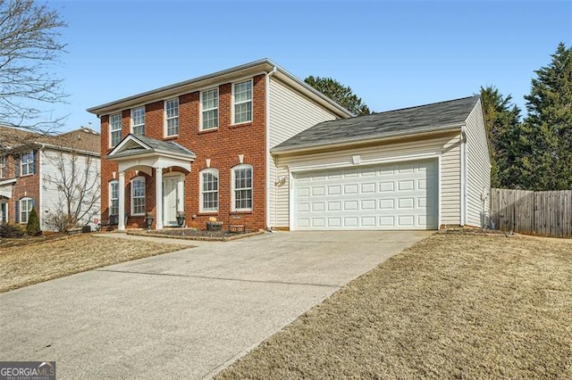 colonial home featuring a front lawn and a garage