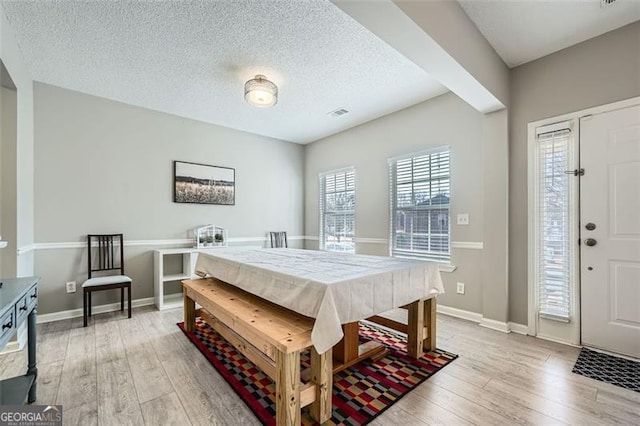 bedroom with a textured ceiling and light hardwood / wood-style floors