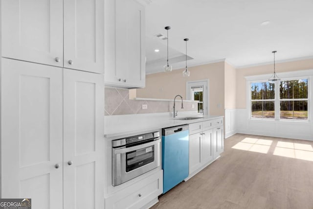 kitchen with stainless steel appliances, white cabinets, hanging light fixtures, and sink