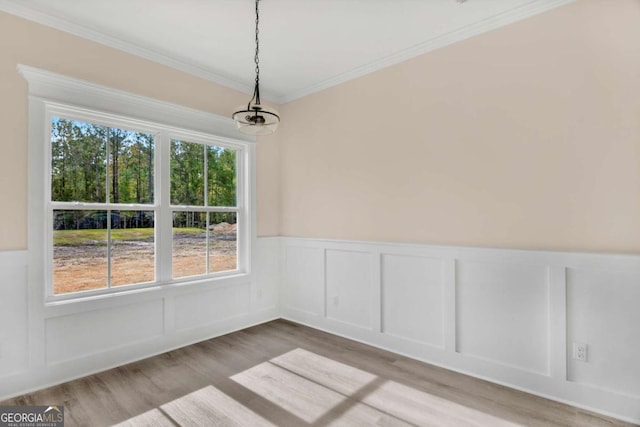 unfurnished dining area featuring ornamental molding and wood-type flooring