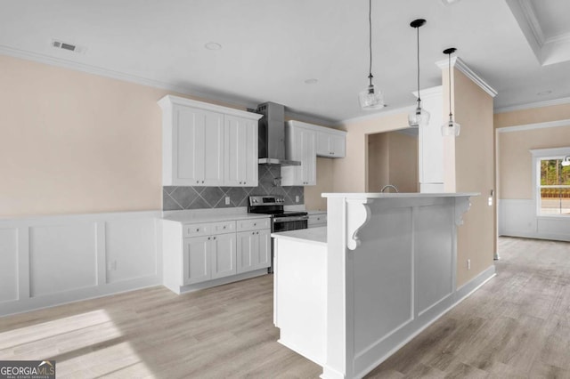 kitchen featuring white cabinetry, wall chimney range hood, stainless steel range with electric cooktop, and tasteful backsplash