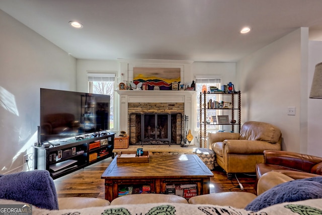 living room with hardwood / wood-style floors and a stone fireplace