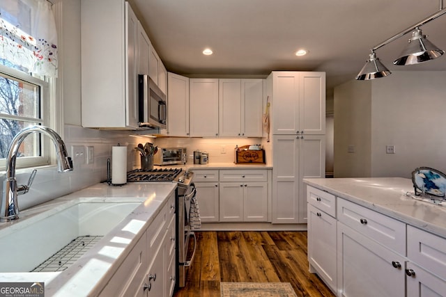 kitchen with sink, dark hardwood / wood-style flooring, white cabinets, and appliances with stainless steel finishes