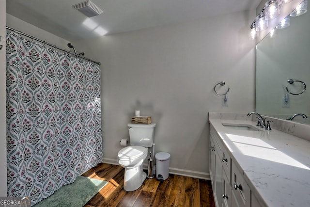 bathroom featuring toilet, vanity, and hardwood / wood-style floors