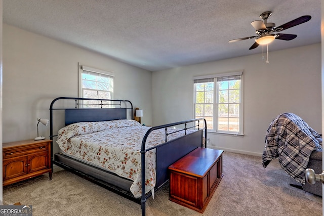 bedroom featuring a textured ceiling, ceiling fan, and light carpet