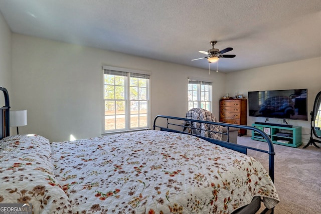 carpeted bedroom with a textured ceiling and ceiling fan