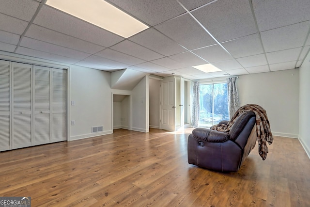 sitting room with a paneled ceiling and wood-type flooring