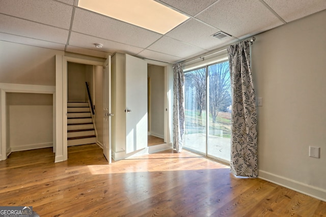 spare room with hardwood / wood-style flooring and a paneled ceiling