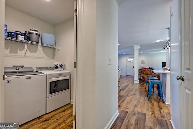 washroom featuring independent washer and dryer, wood-type flooring, and ornate columns