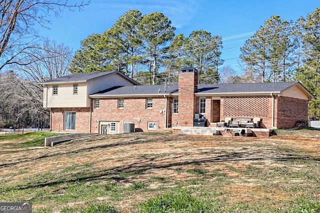 back of property with central air condition unit, a patio area, and a lawn