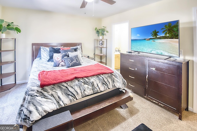 carpeted bedroom with ensuite bath and ceiling fan