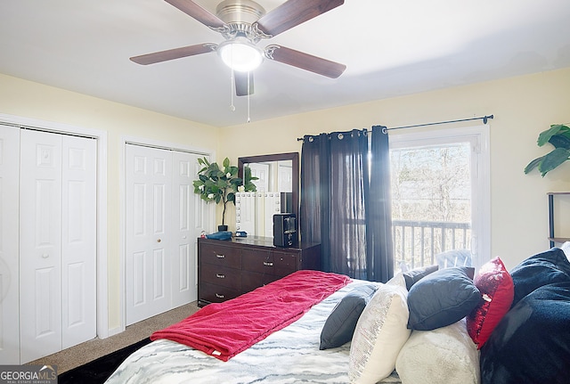 carpeted bedroom featuring ceiling fan and multiple closets