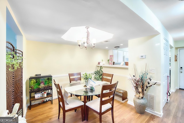 dining room with a notable chandelier and light hardwood / wood-style flooring