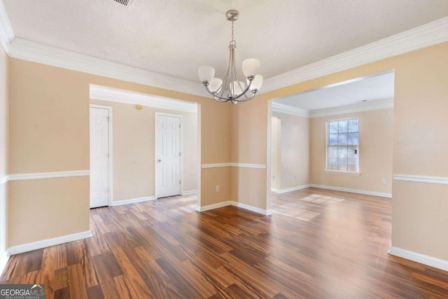 empty room featuring a notable chandelier, dark hardwood / wood-style flooring, crown molding, and a textured ceiling