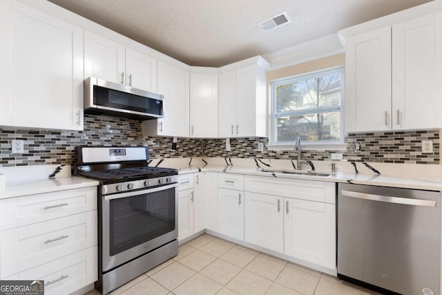 kitchen with appliances with stainless steel finishes, tasteful backsplash, and white cabinetry