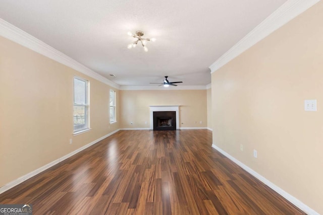 unfurnished living room featuring ceiling fan, crown molding, and dark wood-type flooring