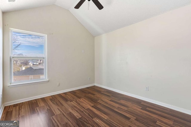 empty room with ceiling fan, vaulted ceiling, and dark wood-type flooring