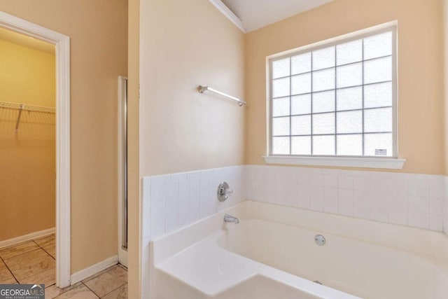 bathroom with a bath, a wealth of natural light, and tile patterned floors