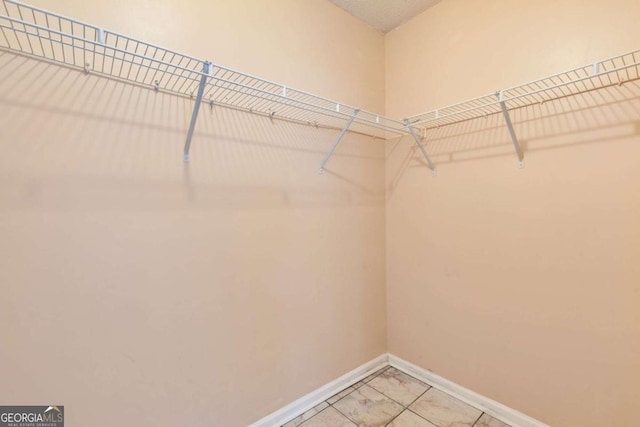 spacious closet featuring light tile patterned flooring