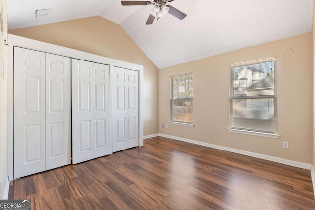 unfurnished bedroom with ceiling fan, dark wood-type flooring, and vaulted ceiling