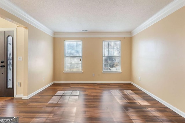 foyer entrance featuring a textured ceiling, ornamental molding, and dark hardwood / wood-style floors