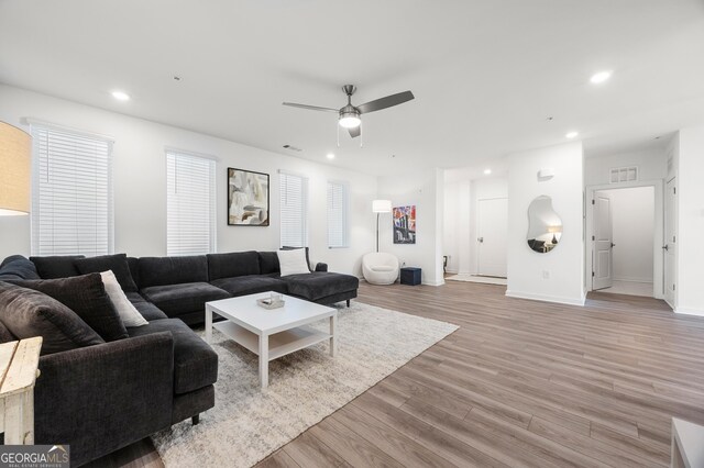 living room with ceiling fan and light hardwood / wood-style flooring