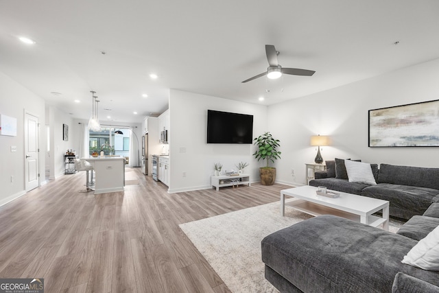 living room featuring ceiling fan and light hardwood / wood-style floors