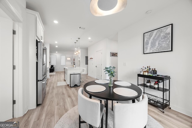 dining area featuring light hardwood / wood-style floors and sink