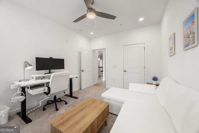 office area with ceiling fan and light colored carpet