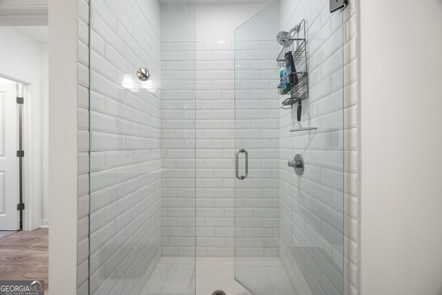 bathroom featuring wood-type flooring and an enclosed shower