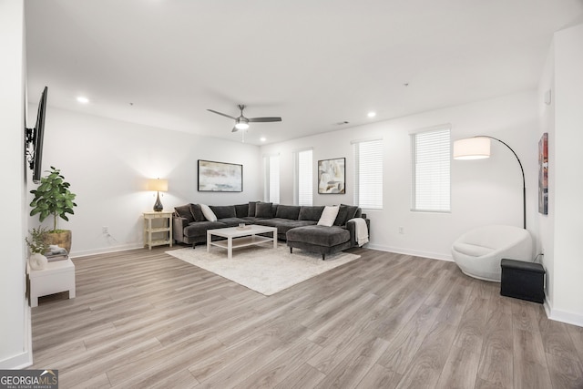 living room featuring ceiling fan and light hardwood / wood-style floors