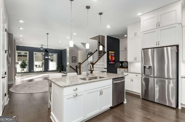 kitchen with sink, decorative light fixtures, white cabinets, and appliances with stainless steel finishes