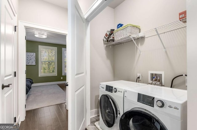 clothes washing area featuring wood-type flooring and washer and clothes dryer