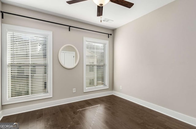 spare room with dark hardwood / wood-style flooring and ceiling fan