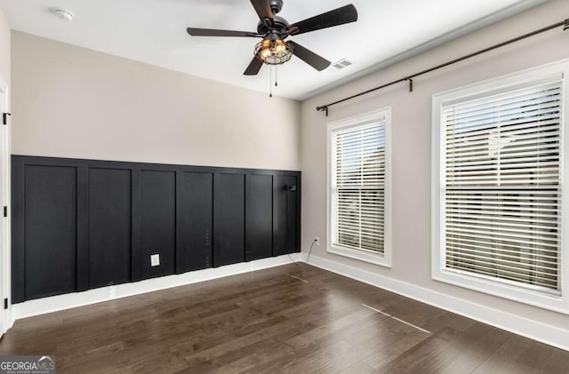 spare room with dark wood-type flooring and ceiling fan