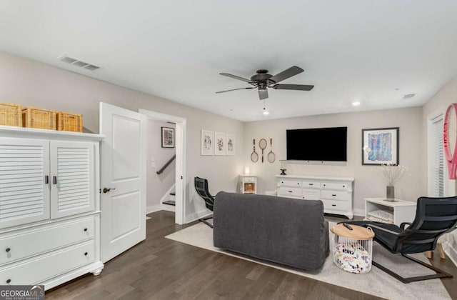 living room featuring dark hardwood / wood-style flooring and ceiling fan